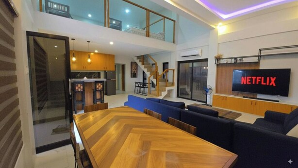 A modern apartment with a dining area, living room, kitchen, and a balcony. - SC RESORT (Concepcion)