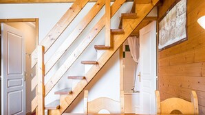 A wooden staircase leading to a bedroom with a bed and a bathroom visible in the background. - Charming apartment for 4 with mezzanine, near slopes in Plagne Villages (Plagne Villages)