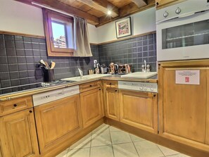 Eine Küche mit Holzausstattung, Geschirrspüler, Herd und integriertem Backofen.