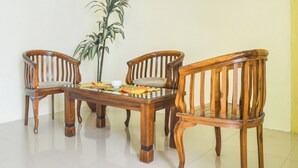 A dining table with four wooden chairs, a potted plant, and a bowl.