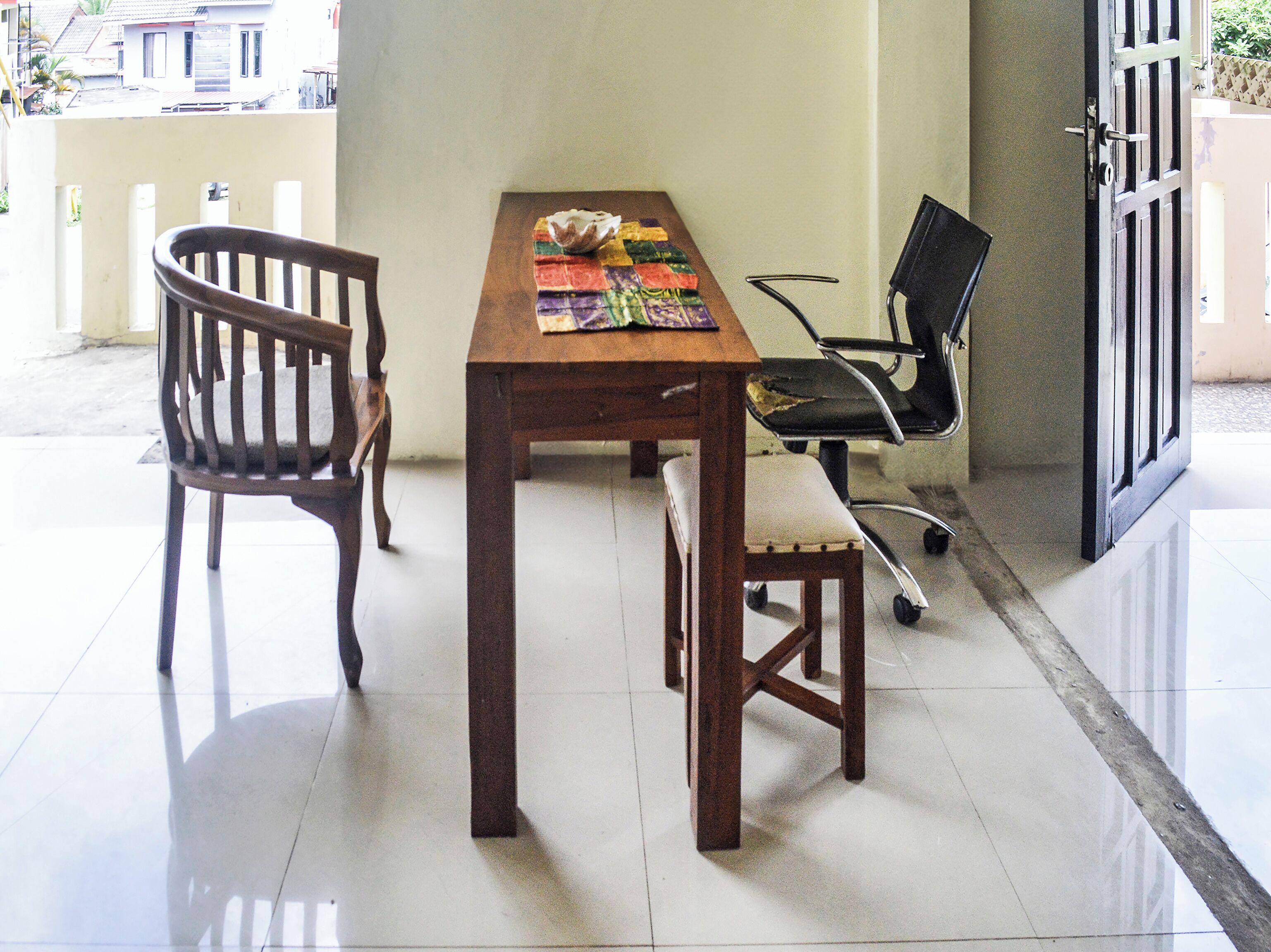 A dining area with a wooden table, a bench, and a chair.