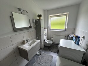 Een haardroger, handdoeken, zeep, toiletpapier