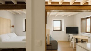 A modern, open-plan living space with a bed, seating area, and a dining table. - Otero de Campoo (Hermandad de Campoo de Suso)
