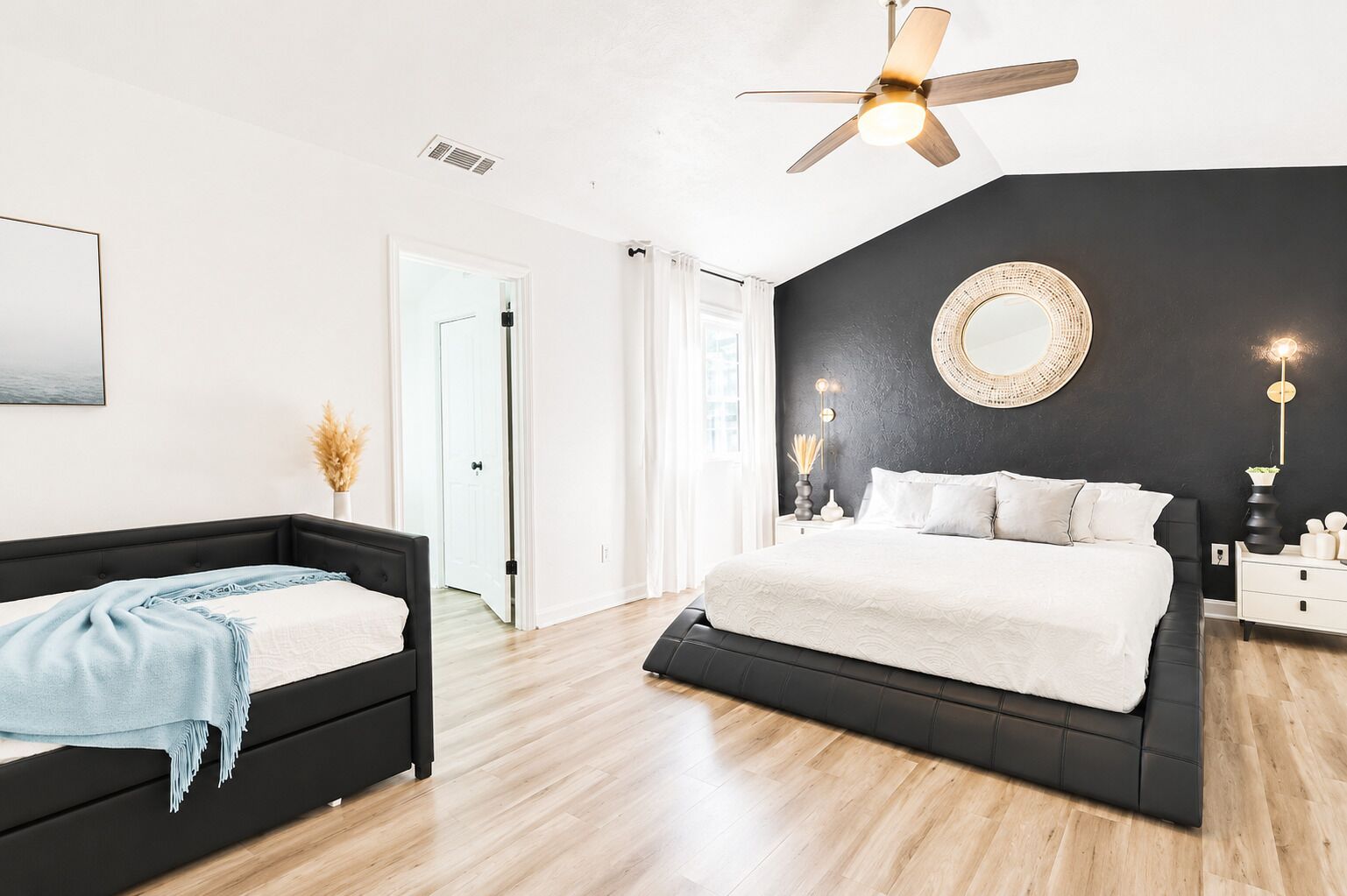 Un dormitorio con una cama, una mesita de noche y un ventilador de techo.