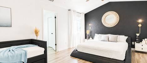 Un dormitorio con una cama, una mesita de noche y un ventilador de techo.