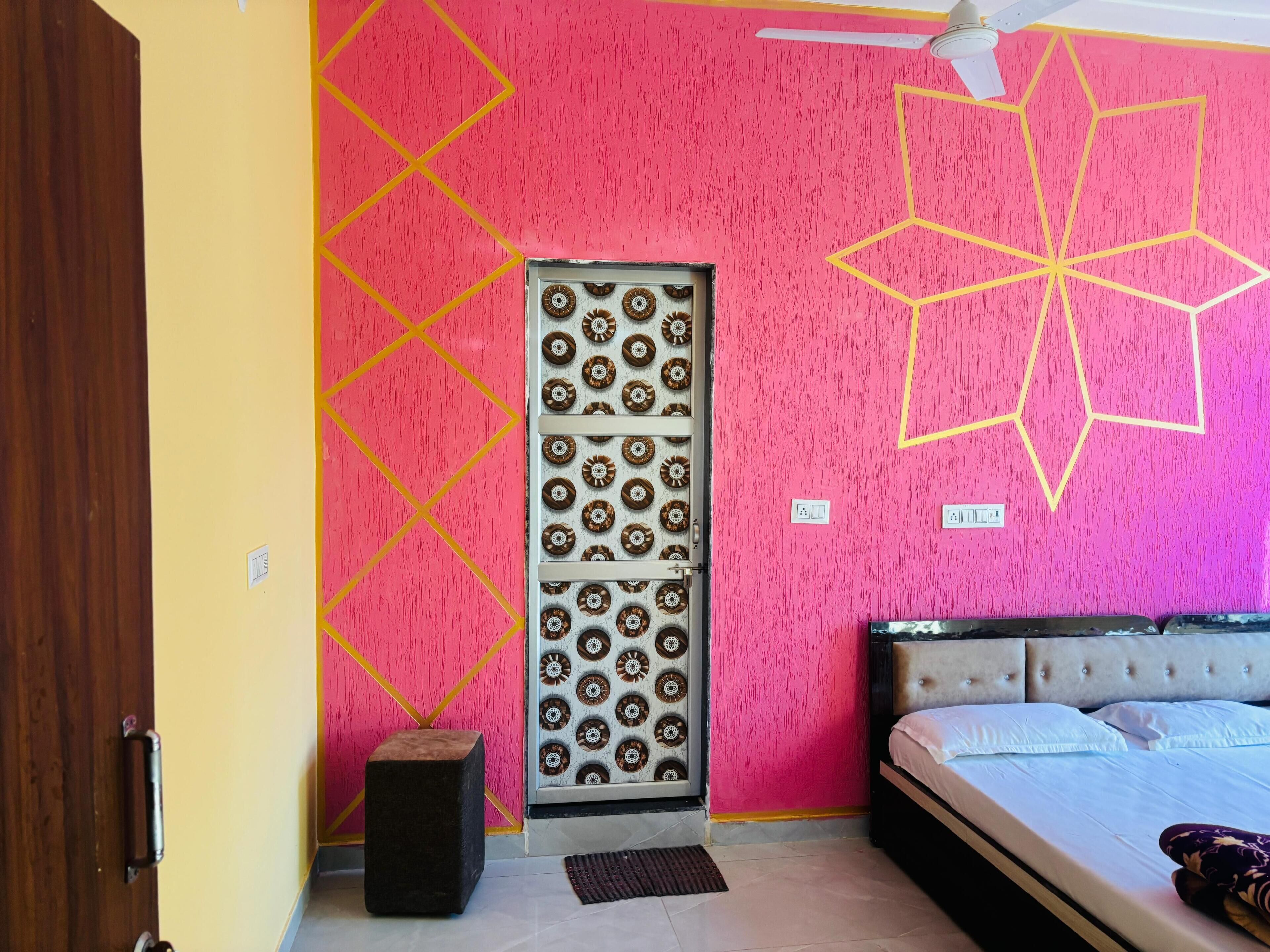 A bedroom with a bed, a door with a decorative panel, and a ceiling fan.