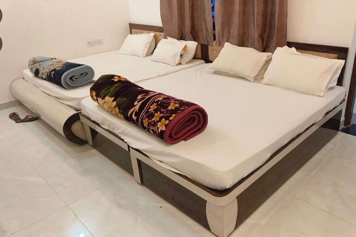 A neatly made bed with a rolled-up blanket, a pillow, and a folded towel on a white mattress.
