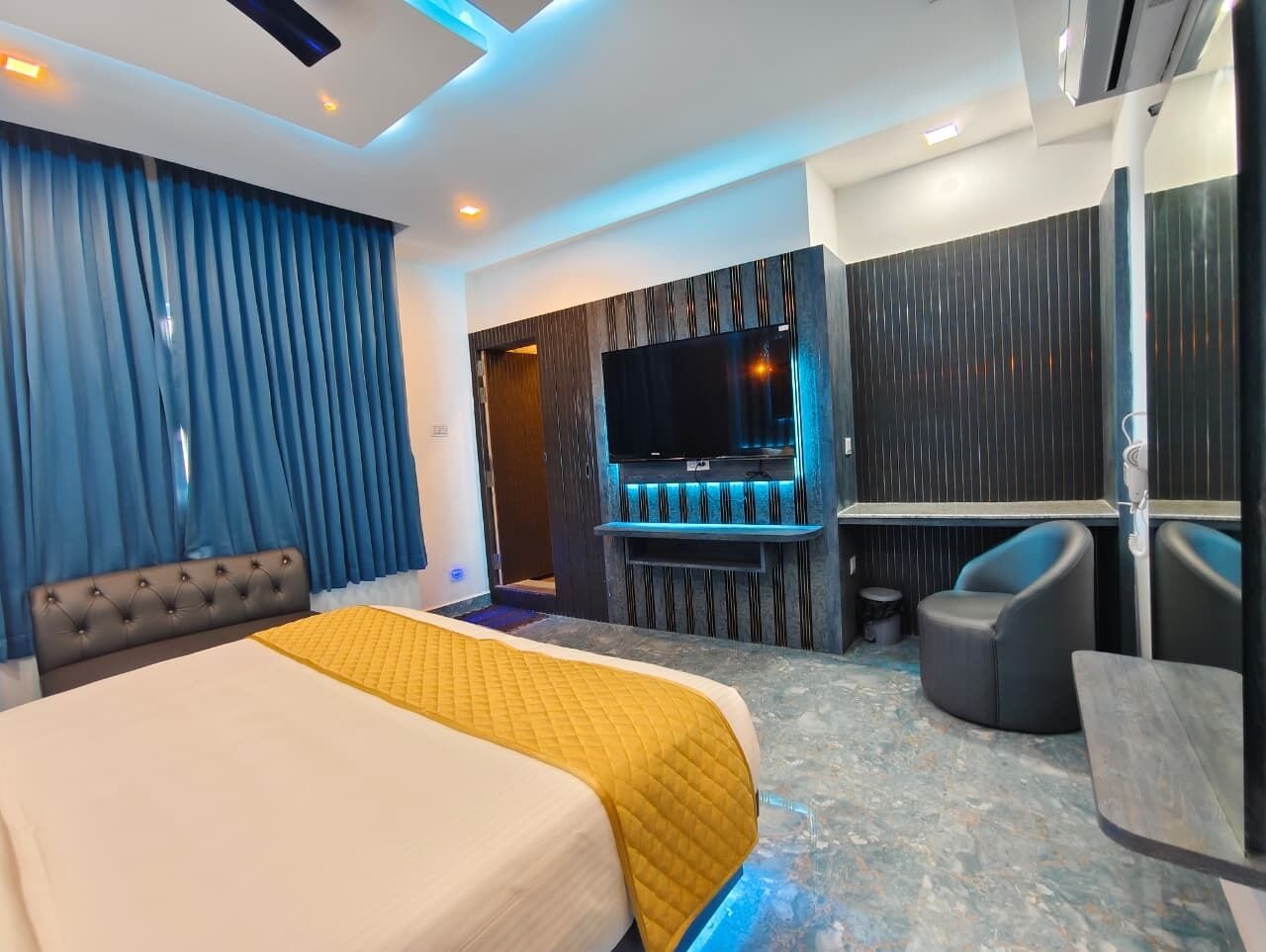 Une chambre d’hôtel équipée d’un lit, d’une télévision, d’un bureau et d’un coin salon.