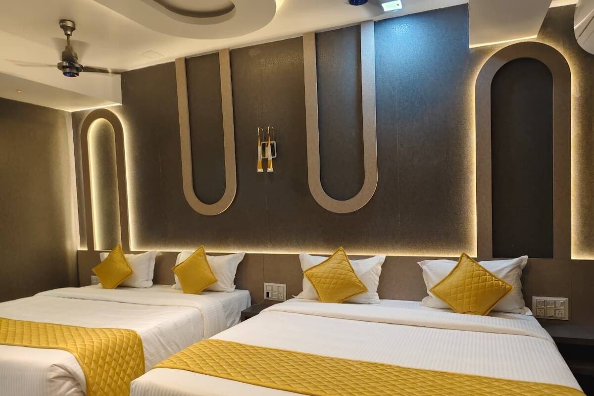 A hotel room with two beds, a modern design, and a ceiling fan.