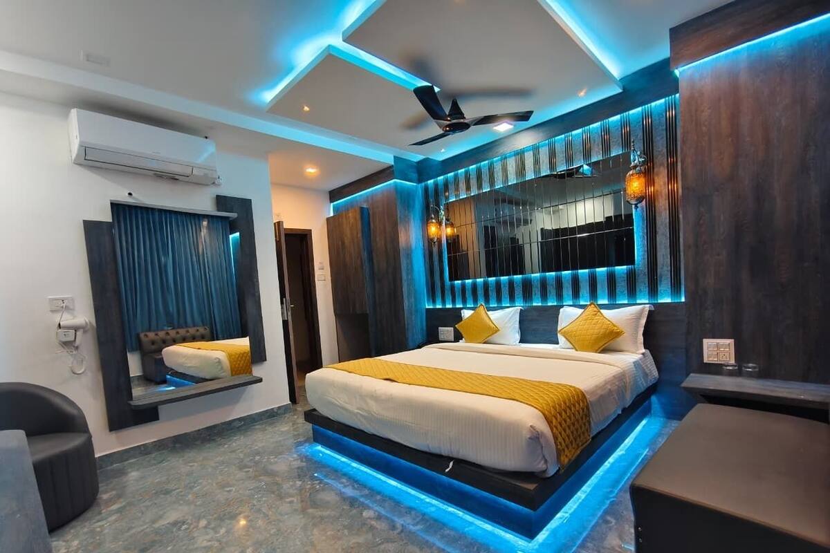 A modern bedroom with a bed, a ceiling fan, and a built-in TV.
