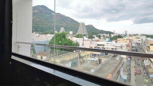 Vista desde un balcón que domina un paisaje urbano con edificios y una montaña.