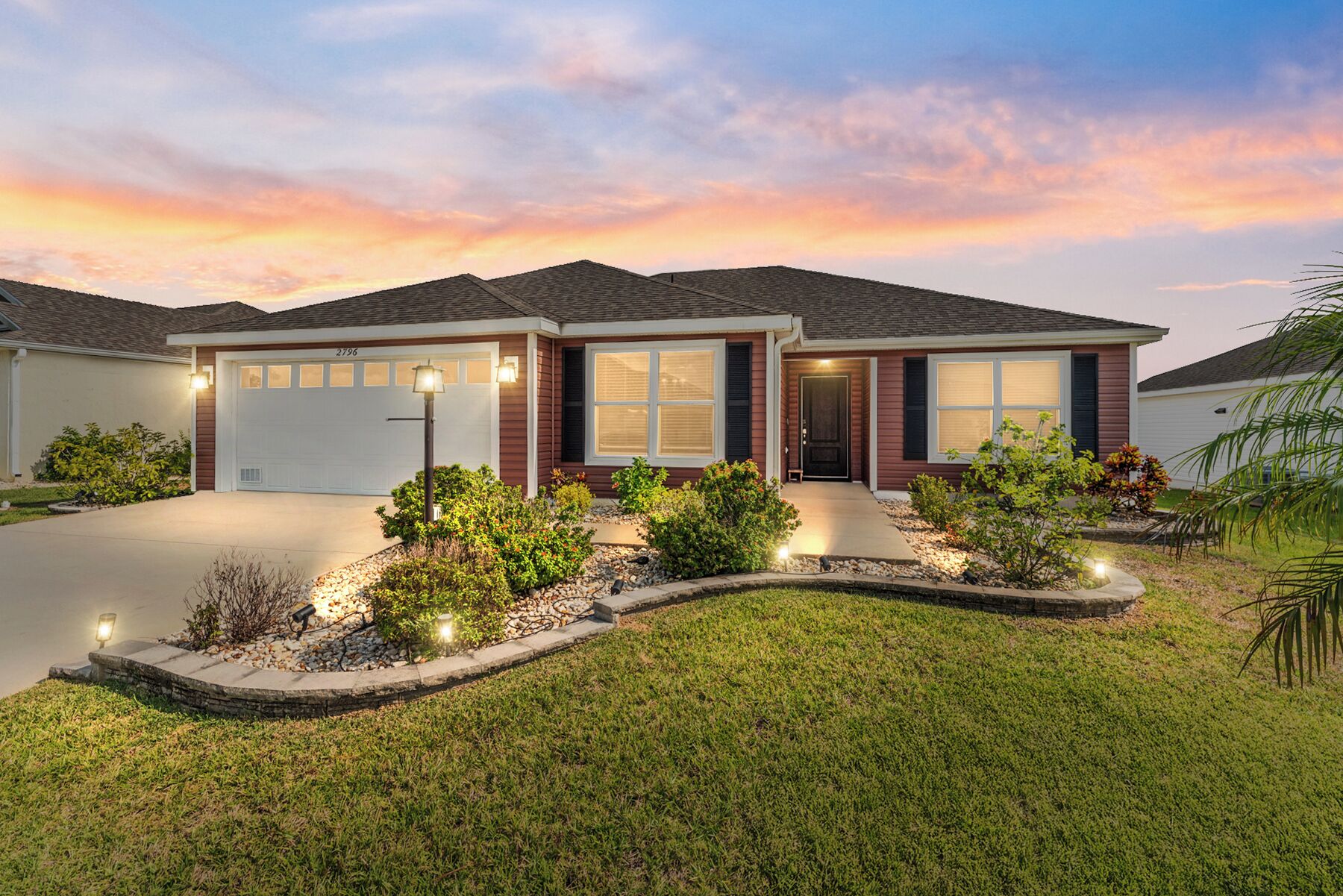A modern two-story house with a well-maintained lawn and landscaped garden.