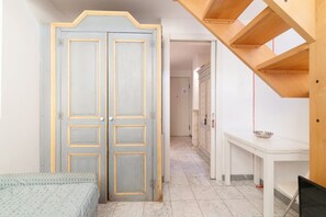 A bedroom with a bed, a wardrobe, a desk, and a staircase.