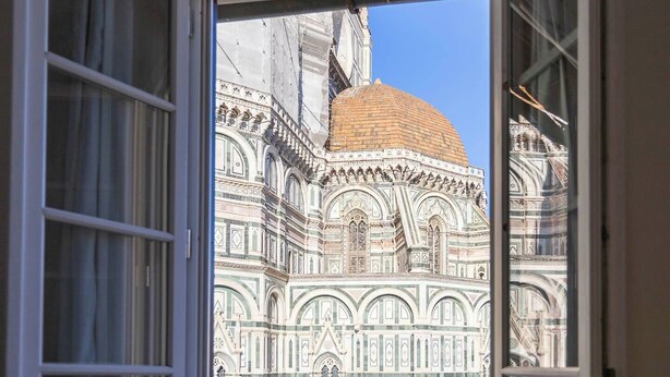 A view of the Florence Cathedral's facade through an open window. - Pallottole Duomo Apartments (Florence)