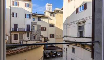 Una calle estrecha flanqueada por edificios, con balcones y ventanas.