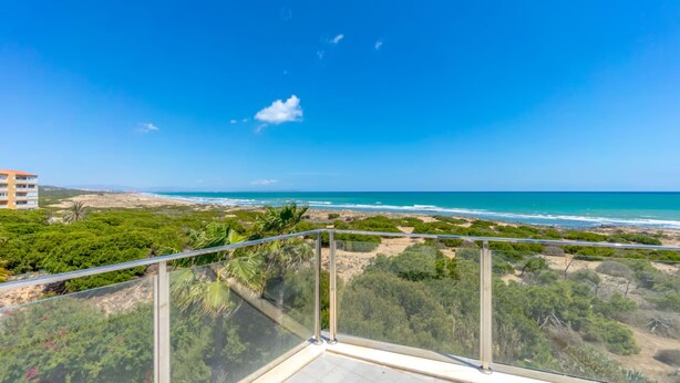 Ein Balkon mit freiem Blick auf Strand und Meer.