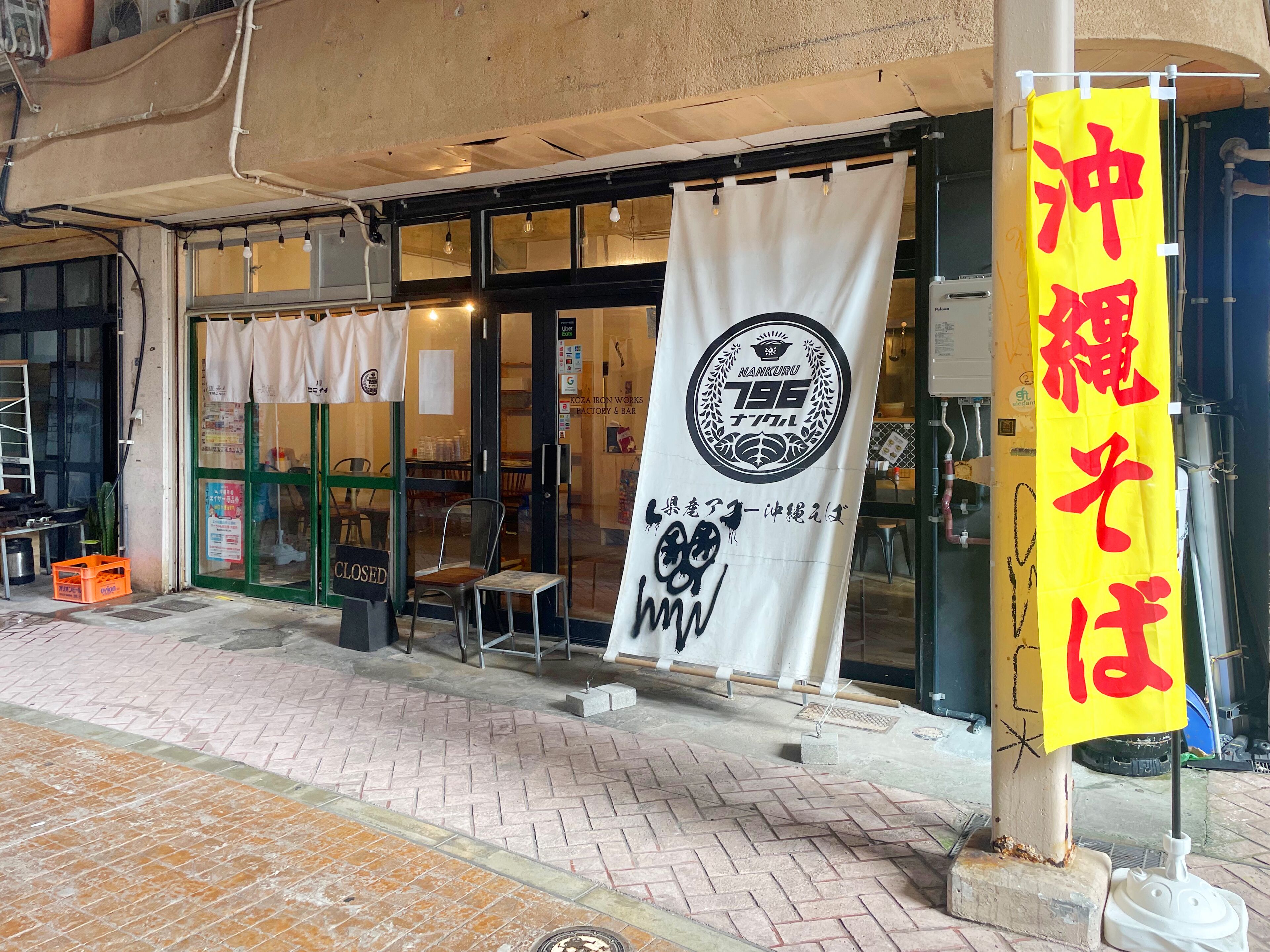 A storefront with a closed sign, a yellow banner with red text, and a white banner with black text.