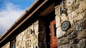 A stone building with a wooden door and a sign that reads "The Granary." - The Granary - Rustic Retreats (Reynoldston)