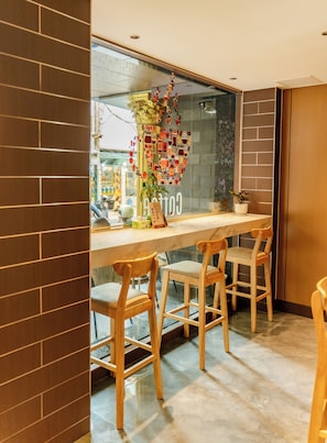 Una cocina moderna con encimera de mármol, sillas de madera y una obra de arte decorativa en la pared.