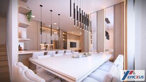 Un comedor de hotel moderno con una larga mesa blanca, sillas blancas tapizadas, iluminación colgante y un espejo grande en la pared.