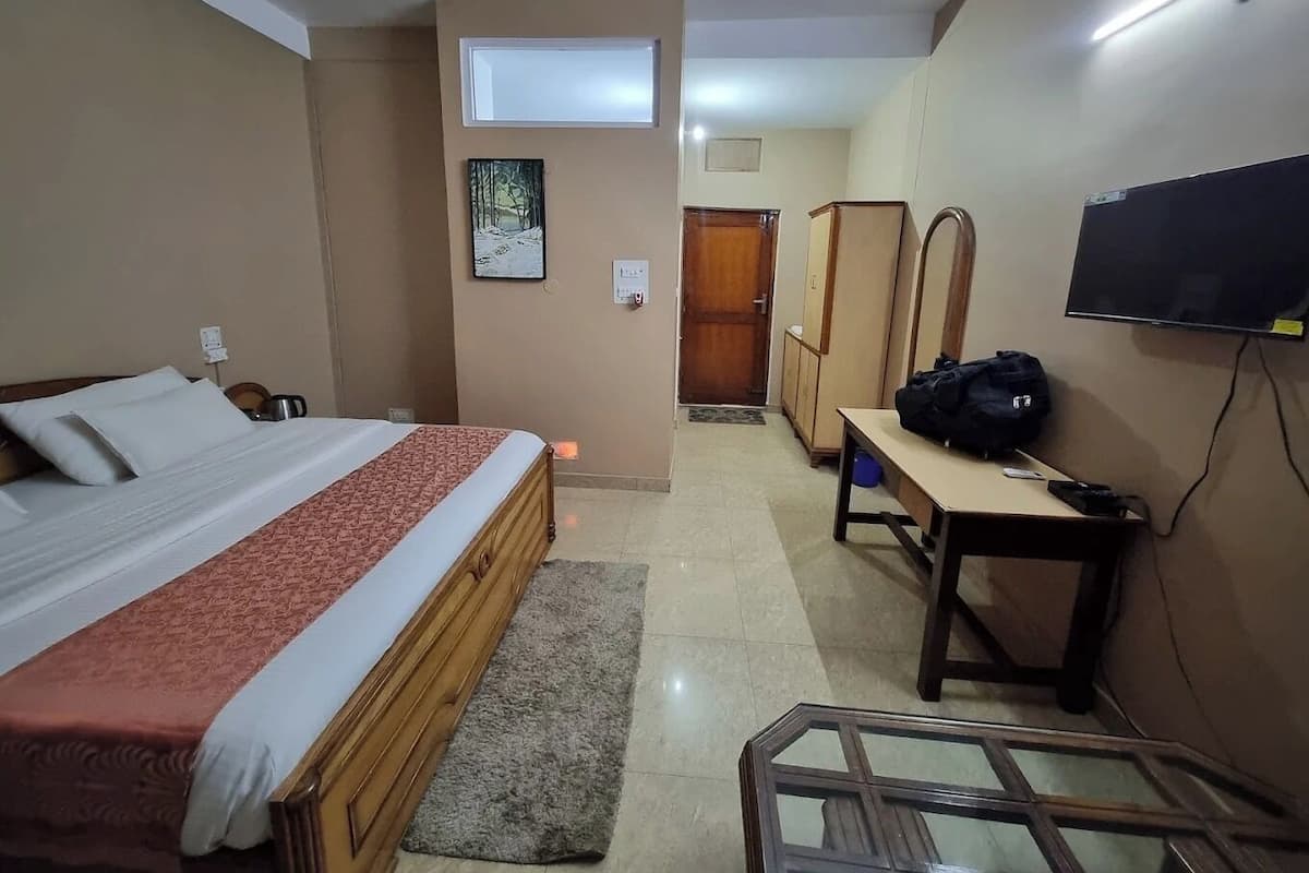 Ein Hotelzimmer mit einem Bett, einem Schreibtisch, einem Fernseher und einem Kleiderschrank.