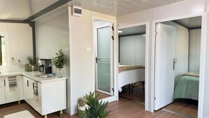 Un espacio habitable compacto con kitchenette, comedor y dormitorio.