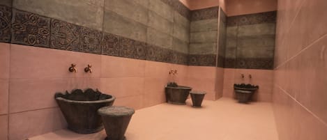 A modern bathroom with large, decorative basins and a tiled floor.