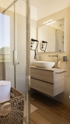A modern bathroom with a glass shower enclosure, a white sink, and a wooden vanity. - MILANO 71 HOME (Milan)