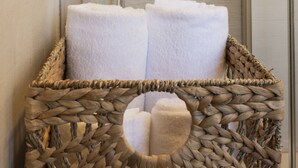 A bathroom with a shower, a towel basket, and a glass shower enclosure. - MILANO 71 HOME (Milan)