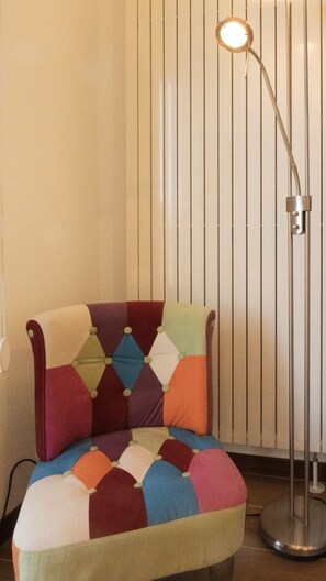 A chair with a patchwork cushion and a floor lamp. - MILANO 71 HOME (Milan)
