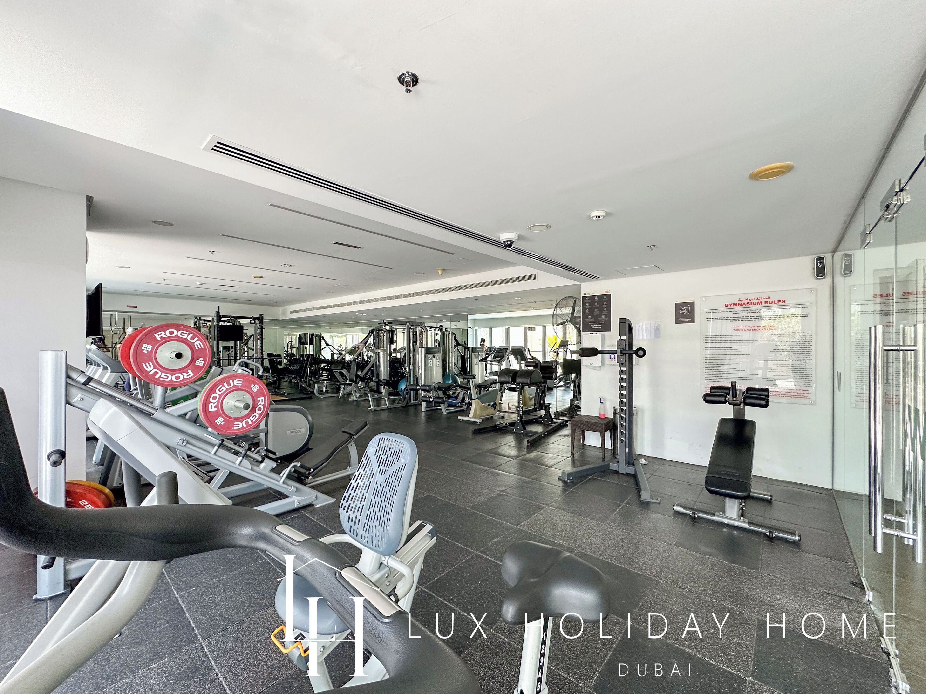 Ein Fitnessstudio mit unterschiedlichen Trainingsgeräten, darunter Kraftgeräte und Kurzhanteln.