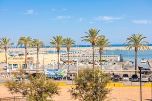 Un port de plaisance avec des bateaux, un espace de stationnement et des palmiers.