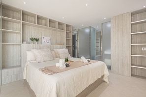 Une chambre à coucher moderne avec un grand lit, des étagères intégrées et un dressing.