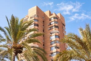 Un immeuble à plusieurs étages doté de balcons et de climatiseurs.