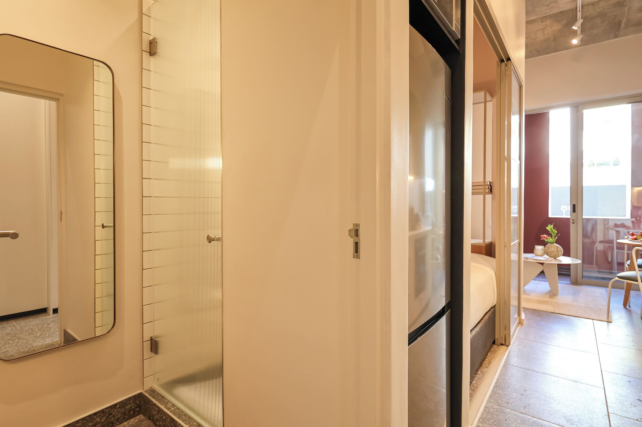 A modern bathroom with a shower, a mirror, and a toilet.