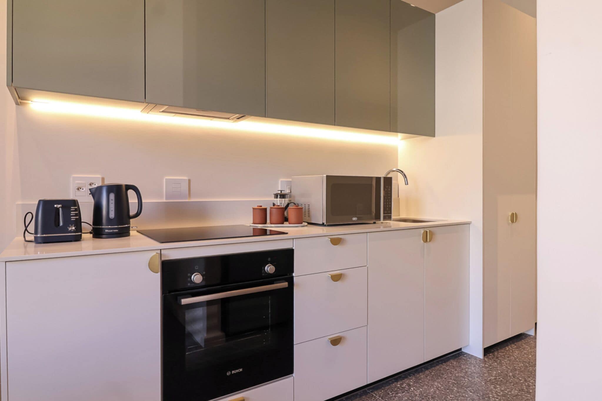 Eine moderne Küche mit Einbauofen, Mikrowelle und Kaffeemaschine.