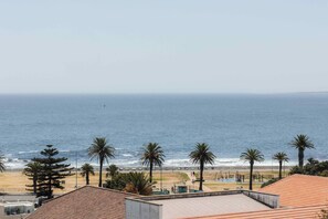 A coastal view with a beach, palm trees, and a clear sky. - ONEHUNDRED on M - Fluent Serviced Apartments (Cape Town)