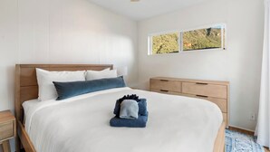 A neatly made bed with a white and blue duvet, a wooden headboard, and a ceiling fan. - Sedona Canyon Whisper: A 3BR retreat in Oak Creek Canyon with stunning red rock views. (Sedona)