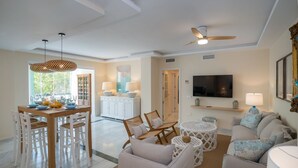 Amplia sala de estar con una mesa de comedor, sillas, un sofá y un televisor.