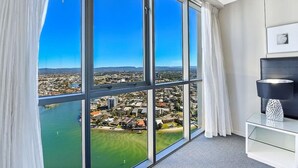 A room with large windows offering a view of a coastal city and a body of water. - The Lookout-Level 33 (Surfers Paradise)