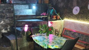 A patio area with a round table and chairs, a small staircase, and potted plants. - Sea view terrace apartment (Arenzano)