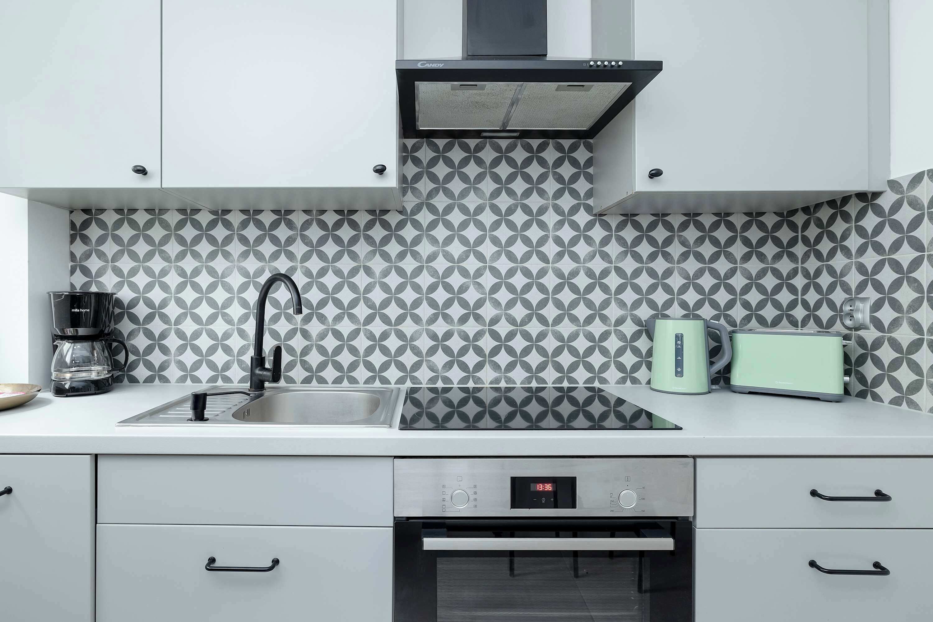 Una cucina moderna con lavello in acciaio inossidabile, un tostapane e una macchina da caffè.