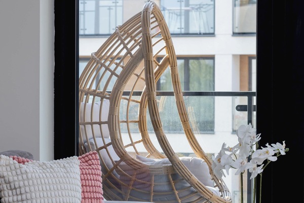 Living room with large windows flooding the room with natural light, highlighting its bright decor.