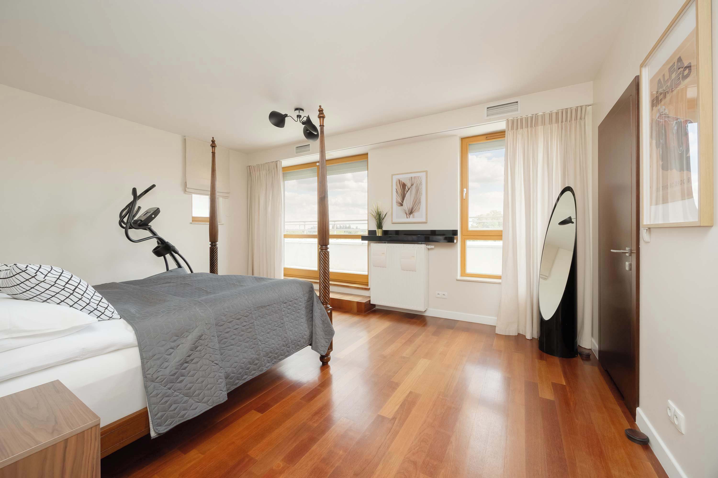 Un dormitorio con cama, escritorio y espejo.