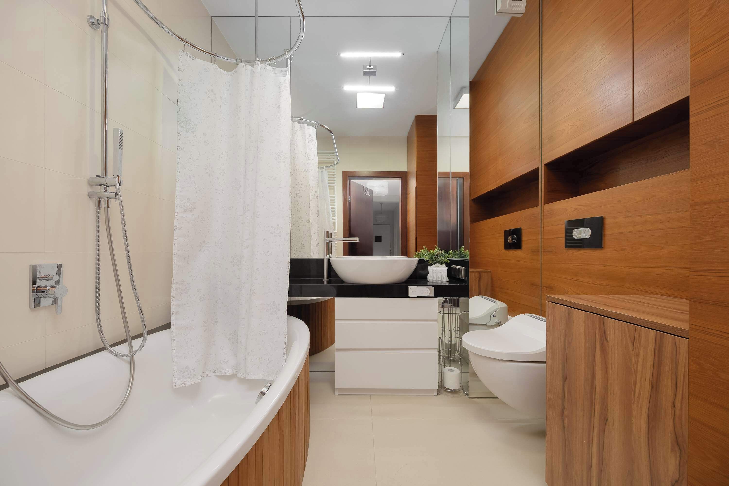 A modern bathroom with a freestanding bathtub, a sink with a vessel basin, and a toilet.