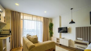 Una sala de estar moderna con un sofá, televisor y una planta.