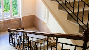 A grand staircase with ornate black railings and golden accents, leading to an upper floor. - Villa Magnolia (Castellammare di Stabia)