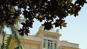 A multi-story building with a balcony, surrounded by lush greenery and a well-maintained garden. - Villa Magnolia (Castellammare di Stabia)