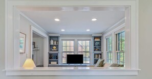A room with a built-in TV, bookshelves, and a window with a view.