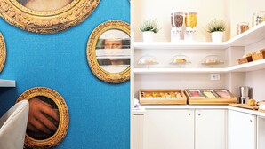 Une pièce ornée de miroirs décoratifs sur les murs, un meuble blanc avec une vitrine, et une étagère où sont disposés des bocaux et des plantes.